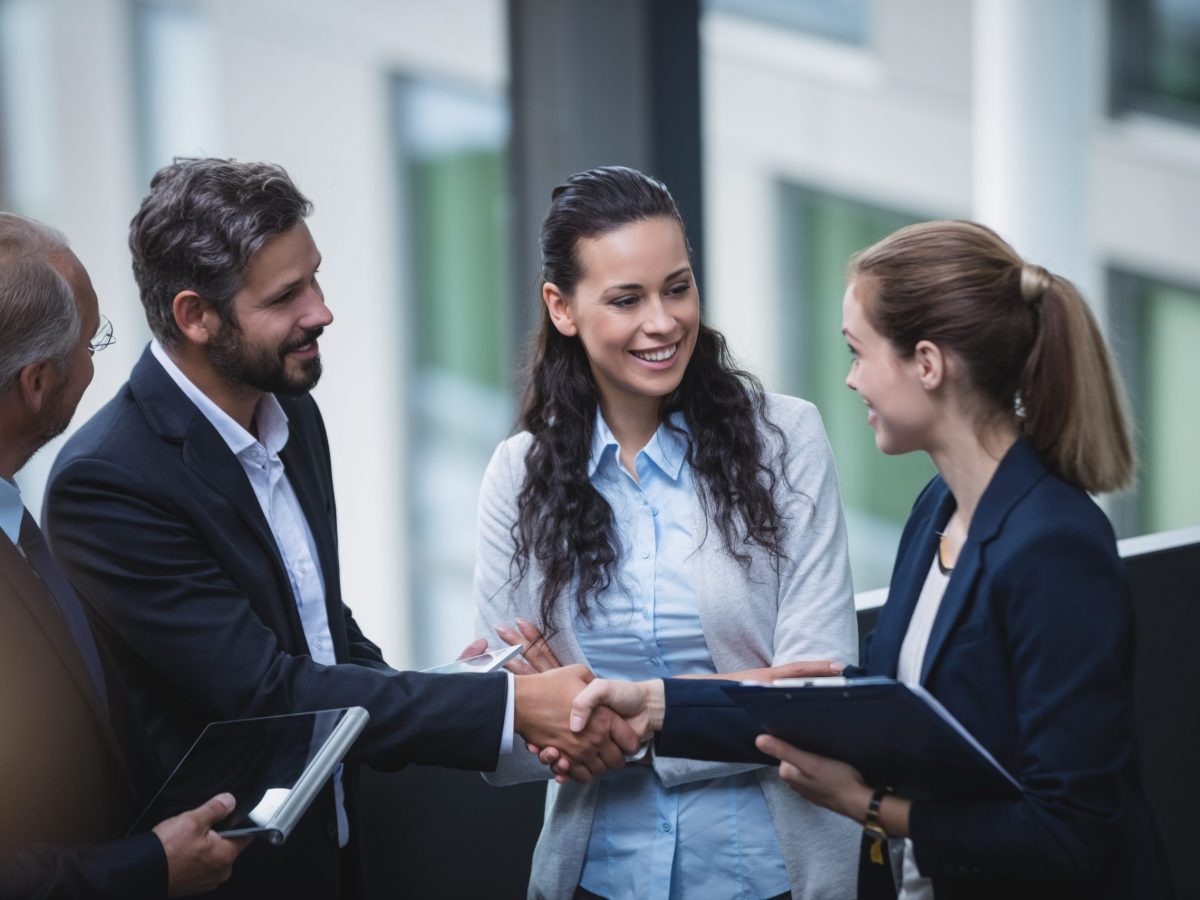 Group of businesspeople having a discussion near staircase in office